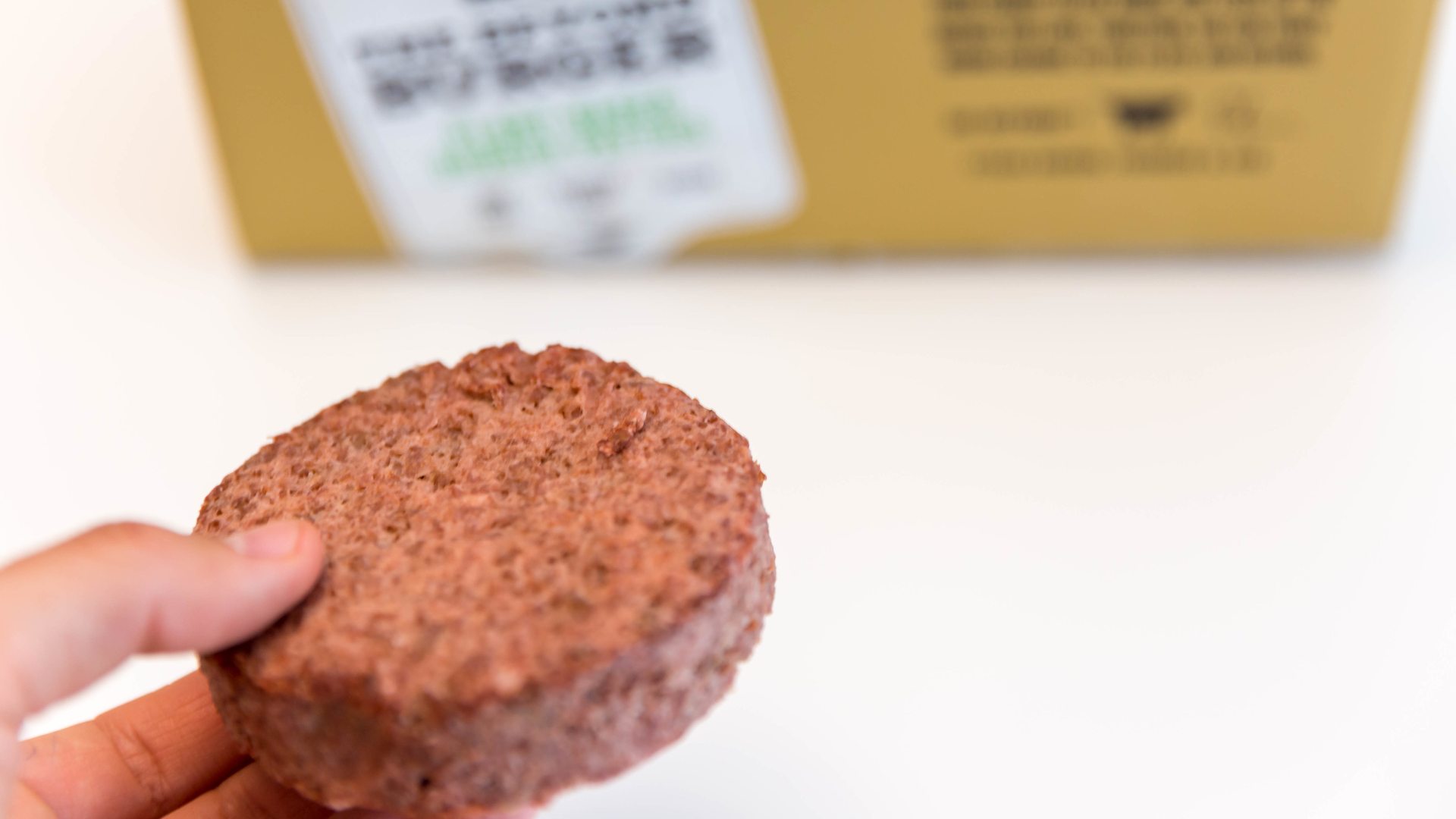'Hand shows Beyond Meat Patty - a healthy, plant-based alternative of burger meat'