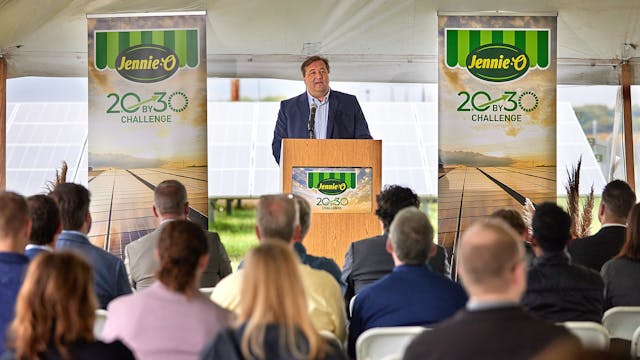 Hormel Foods director of sustainability Tom Raymond speaks to the crowd at the Jennie-O plant in Montevideo, Minn., during the ribbon-cutting ceremony for the new solar field (in the background).
