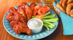 chicken wings with carrots and celery on a plate