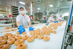 Kwik Trip employees box the convenience store chain&rsquo;s famous glazed donuts, which are made fresh daily at its La Crosse headquarters. Kwik Trip is spending $151 million to expand its operations, most of them bakeries, at multiple locations throughout Wisconsin.