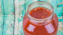Spaghetti sauce in a glass jar over wooden background
