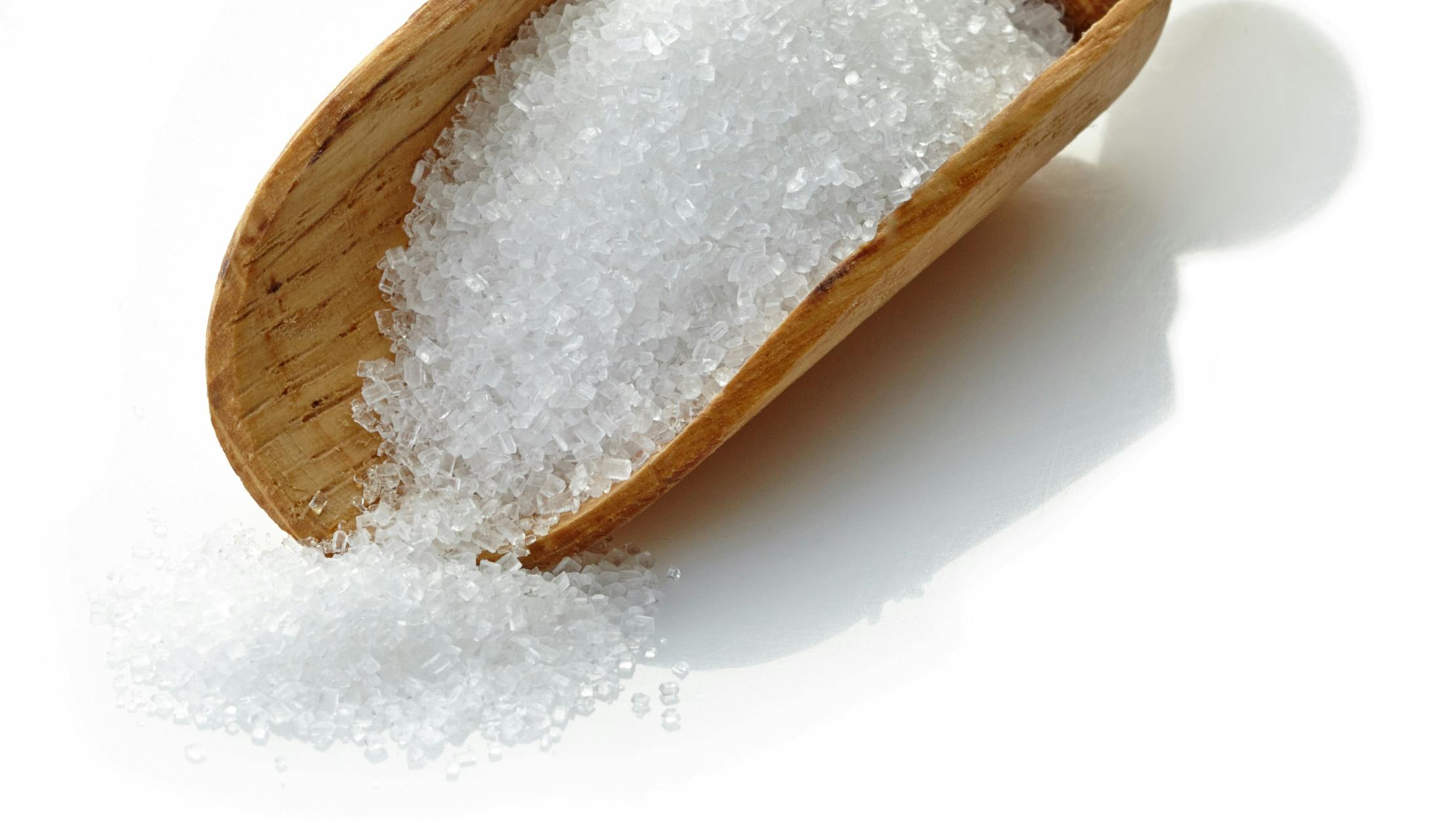 wooden scoop with white sugar