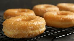 Sweet delicious glazed donuts on grey table Sweet delicious glazed donuts on grey table