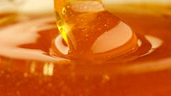 Pouring honey, flowing liquid sugar syrup. Thick Honey Dripping close up Pouring honey, flowing liquid sugar syrup. Thick Honey Dripping close up