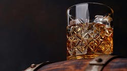 Whiskey glass with ice on a rustic barrel, a classic sip. Whiskey glass with ice on a rustic barrel, a classic sip.