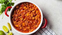 Vegan chili con carne with vegetables and beans in tomato sauce in red saucepan, top view. Vegan chili con carne with vegetables and beans in tomato sauce in red saucepan, top view.