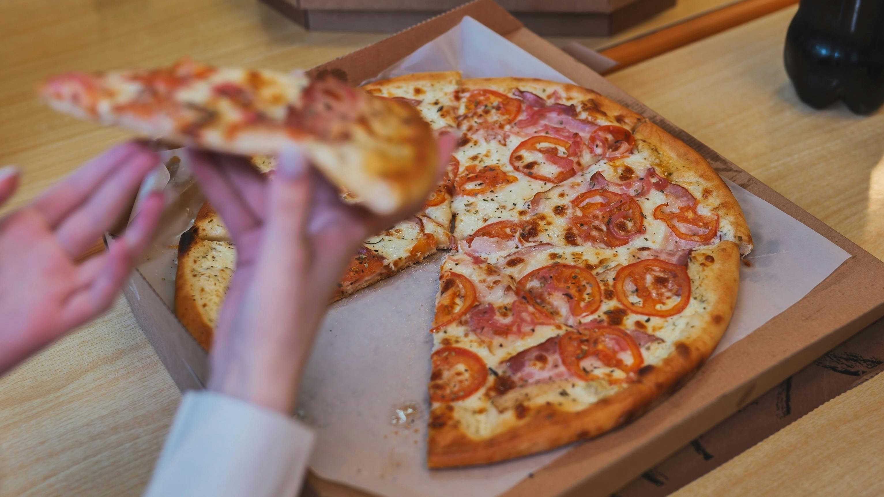 Students take a slice of pizza in the cafeteria
