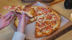 Students take a slice of pizza in the cafeteria Students take a slice of pizza in the cafeteria