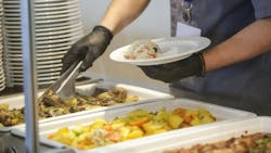 Buffet style service - Canteen worker at serving line putting food on the plate Buffet style service - Canteen worker at serving line putting food on the plate