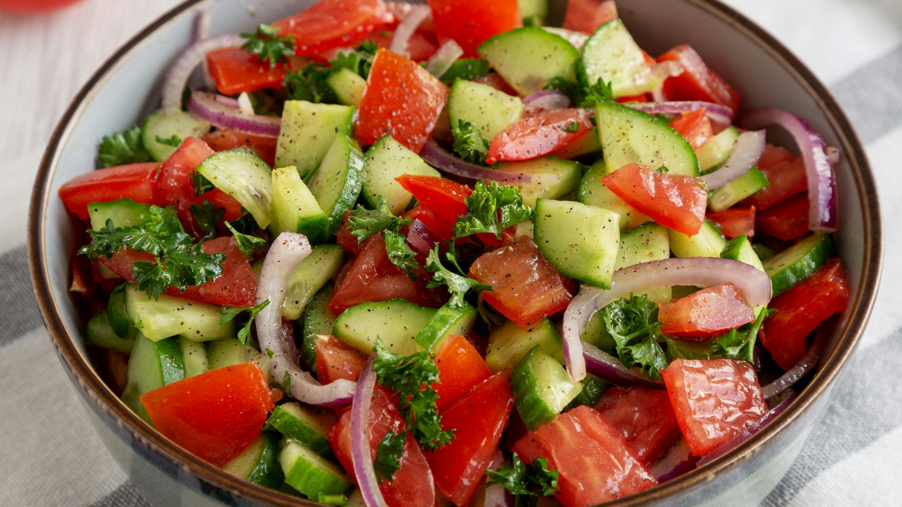 Homemade Mediterranean Cucumber Tomato Salad in a Bowl, side view.