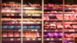 Glass showcase with chilled meat products in the store. Blurred Glass showcase with chilled meat products in the store. Blurred