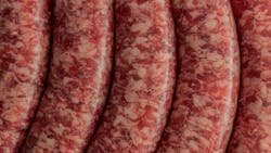 Tight macro shot of fresh Italian sausages, showcasing their marbled appearance and smooth casing Tight macro shot of fresh Italian sausages, showcasing their marbled appearance and smooth casing