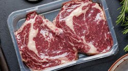 Raw ribeye steaks in package and savory spices Raw ribeye steaks in package and savory spices