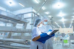Workers in safety gear inside a factory Workers in safety gear inside a factory