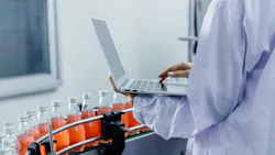 Closeup worker using laptop record products data at production line in food and drinks factory for improve productivity of manufacturing